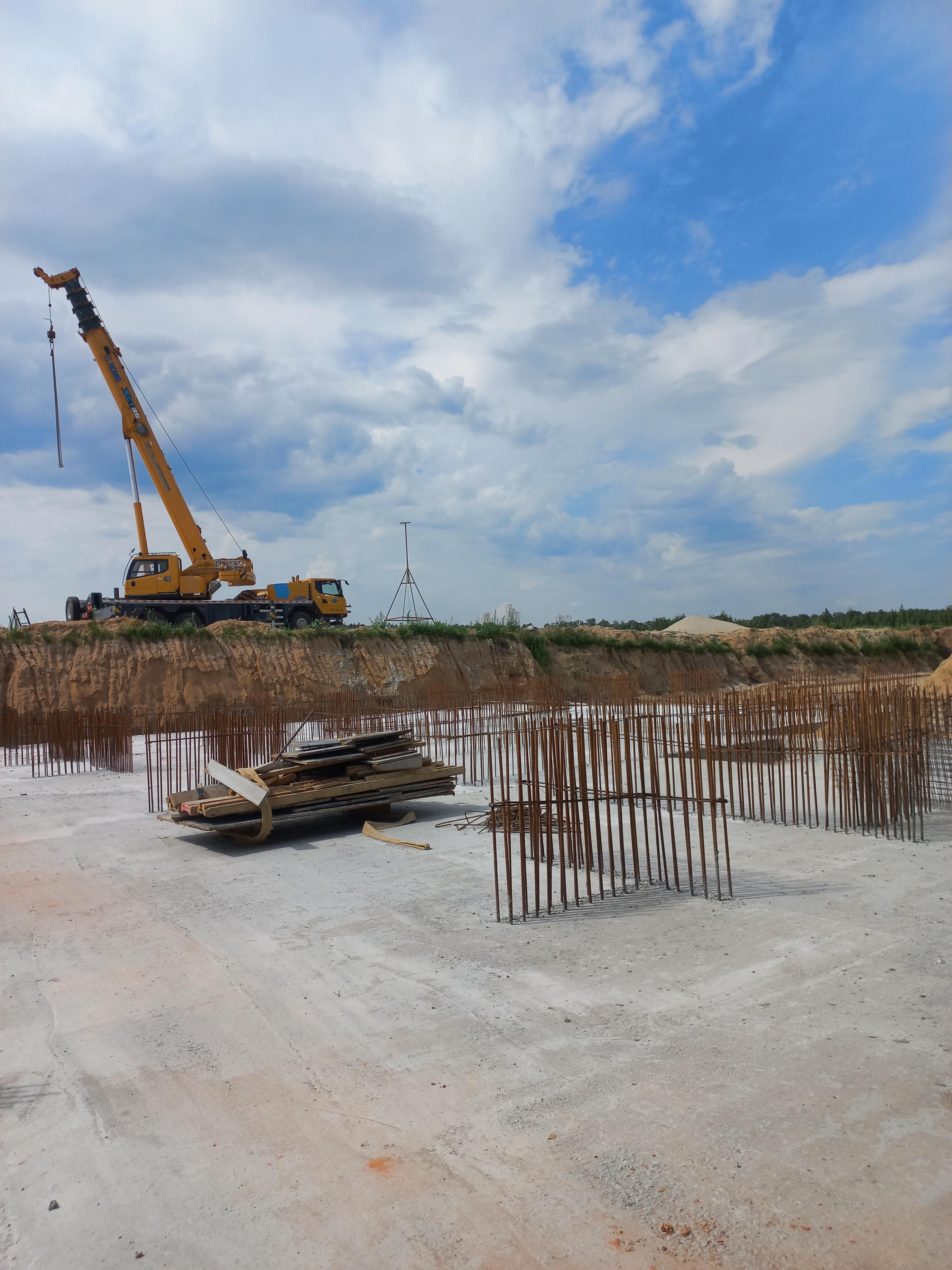 Будівництво багатоповерхових будинків у житловому комплексі Park Royal. Робітники працюють на будівельному майданчику, проводячи монтажні роботи.